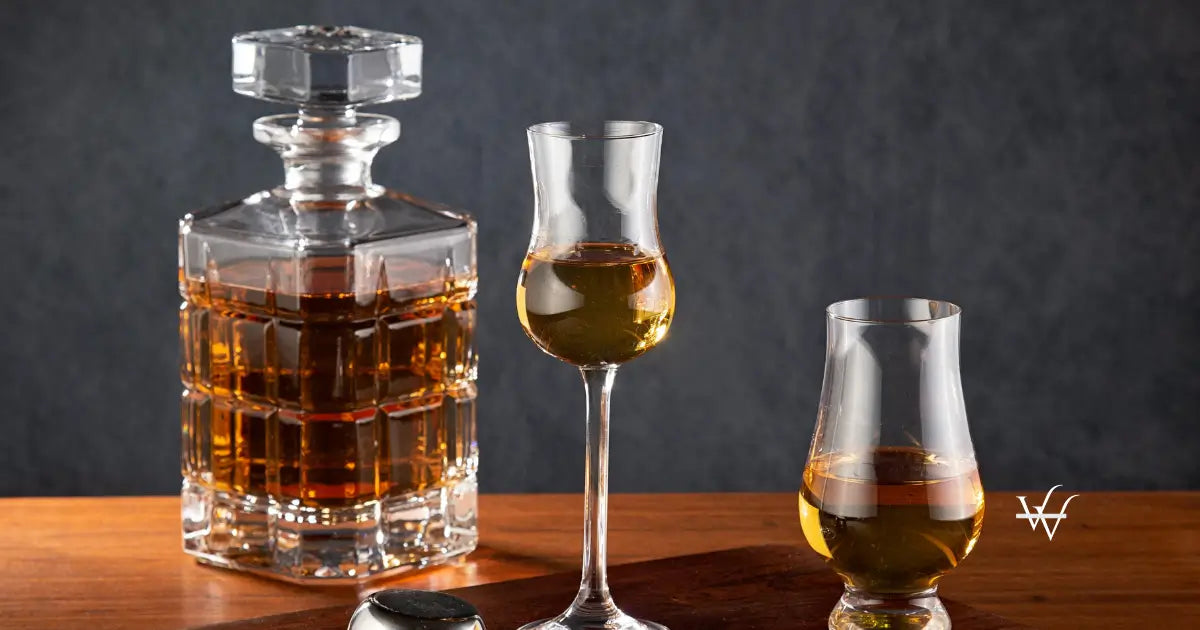 a whiskey decanter and two glasses on a wooden tray