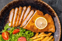 Roast viennese schnitzel steak, breaded meat with salad and french fries